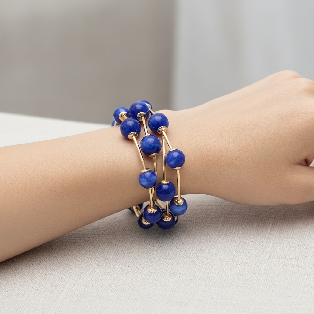 Set of blue beaded bracelets with gold accents on a white background