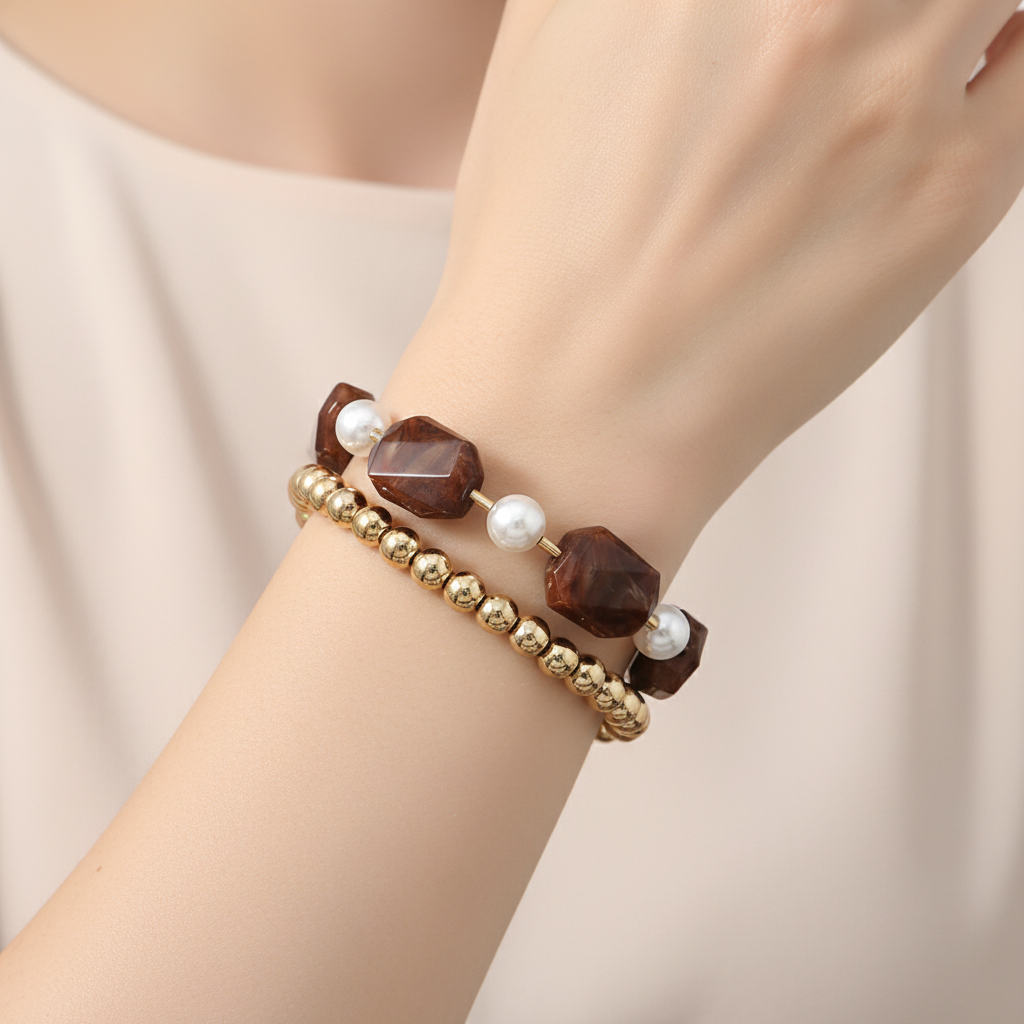 Bracelet with gold beads, brown stones, and pearls on a white background