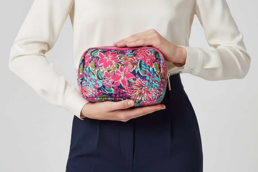 Floral patterned cosmetic bag with pink zipper on a white background