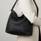 Black woven handbag on a white background