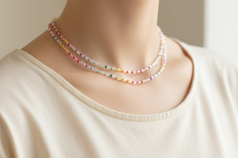 Multistrand beaded necklace on a mannequin neck with a white background