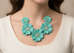 Turquoise flower-shaped necklace with gold accents on a white background