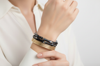 Set of black and gold bracelets on a white background