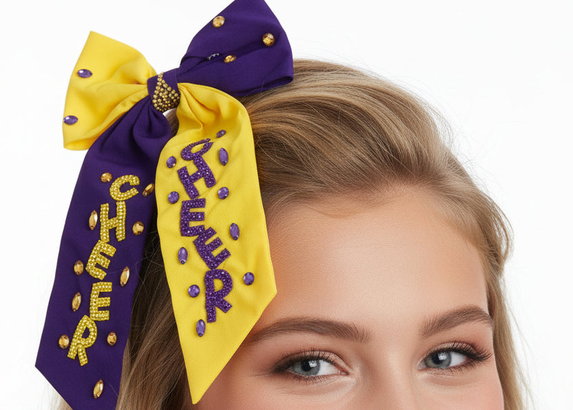 Purple and yellow scarf with a large bow, featuring text and decorative elements on a white background.