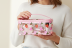 Pink cosmetic bag with strawberry pattern on a light background