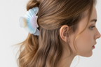 Shell-shaped hair clips in pastel colors on a white surface