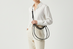 Clear handbag with black handle and trim on a light gray background