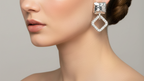 Silver square-shaped earrings with clear gemstones on a white background