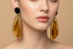 Pair of amber-colored earrings with black accents on a white background