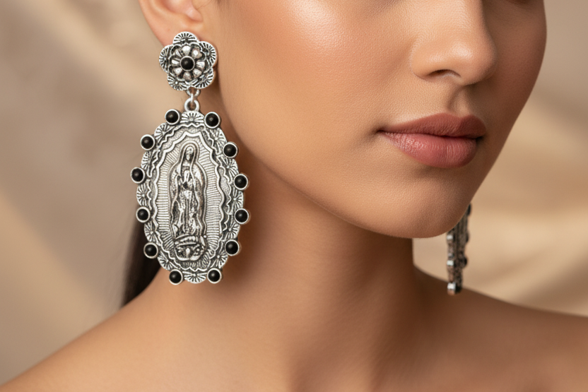 Pair of silver earrings with black accents featuring a religious icon on a white background