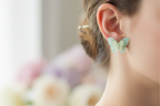 Pair of light blue butterfly-shaped earrings on a white background