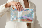 Holographic makeup bag with cosmetic items on a white background