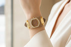 Wristwatch with gold and beige strap on a white background